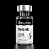 Selank 13mg Close-up of a glass bottle with a silver cap and black label reading Selank and 13 mg, on a black background.