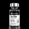 Close-up of a glass peptide vial with a silver cap and black label reading 'TB-500' and 'Peptide' against a black background.